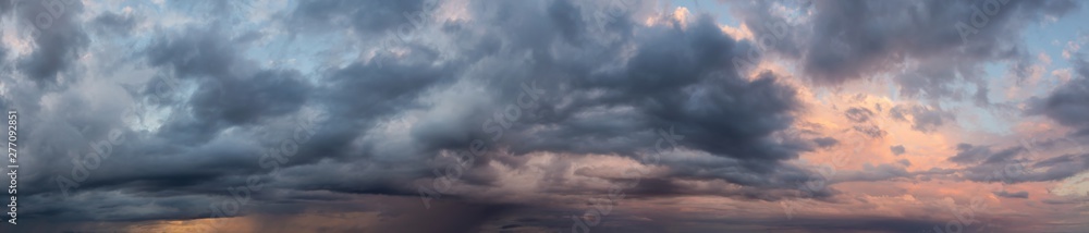 Dramatic Panoramic View of a cloudscape during a dark, rainy and colorful morning sunrise. Taken over Beach Ancon in Trinidad, Cuba.