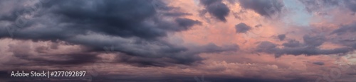 Dramatic Panoramic View of a cloudscape during a dark, rainy and colorful morning sunrise. Taken over Beach Ancon in Trinidad, Cuba.