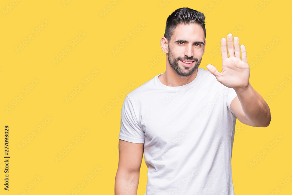Handsome man wearing white t-shirt over yellow isolated background Waiving saying hello happy and smiling, friendly welcome gesture Handsome man wearing white t-shirt over yellow isolated background Waiving saying hello happy and smiling, friendly welcome gesture