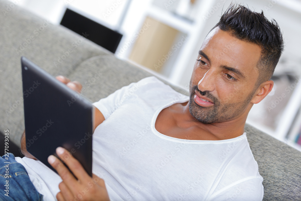 man at home using tablet on the couch man at home using tablet on the couch