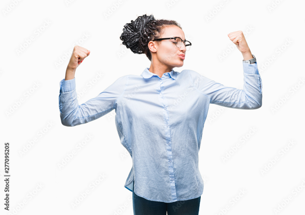 Young braided hair african american business girl wearing glasses over isolated background showing arms muscles smiling proud. Fitness concept. Young braided hair african american business girl wearing glasses over isolated background showing arms muscles smiling proud. Fitness concept.