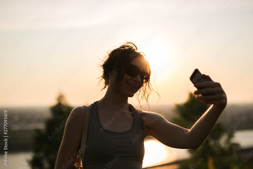 brunette girl phone takes selfie while jogging