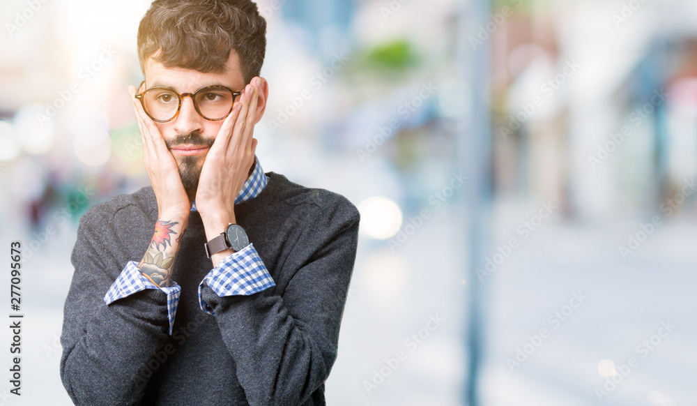 Young handsome smart man wearing glasses over isolated background Tired hands covering face, depression and sadness, upset and irritated for problem Young handsome smart man wearing glasses over isolated background Tired hands covering face, depression and sadness, upset and irritated for problem