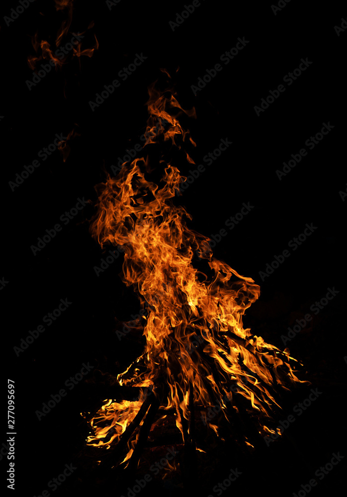Fire flames on black background. Solitary flame burning in splinters in the night cold ground. Fire flames on black background. Solitary flame burning in splinters in the night cold ground.