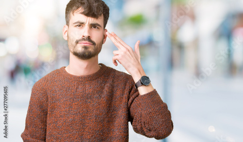 Photography Young handsome man wearing winter sweater over isolated background Shooting and killing oneself pointing hand and fingers to head, suicide gesture
