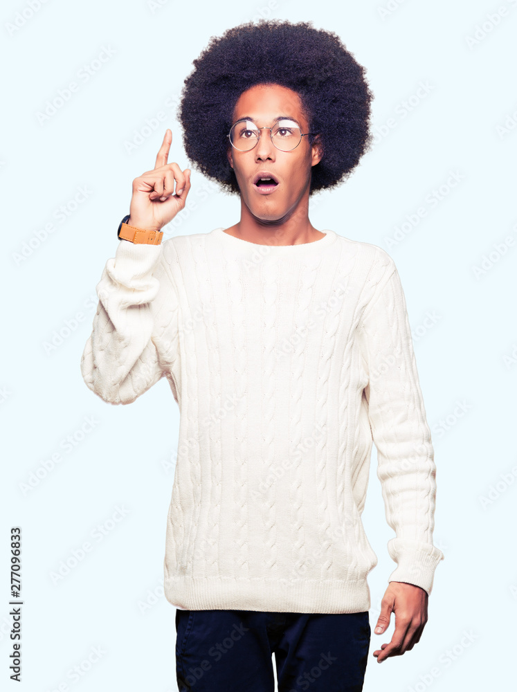 Young african american man with afro hair wearing glasses pointing finger up with successful idea. Exited and happy. Number one. Young african american man with afro hair wearing glasses pointing finger up with successful idea. Exited and happy. Number one.