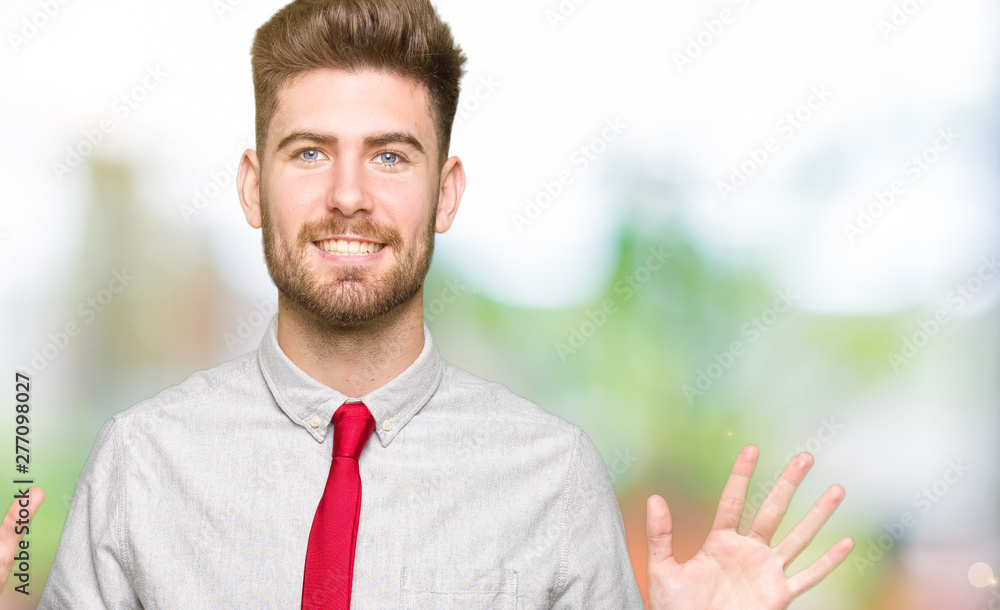 Young handsome business man showing and pointing up with fingers number ten while smiling confident and happy. Young handsome business man showing and pointing up with fingers number ten while smiling confident and happy.