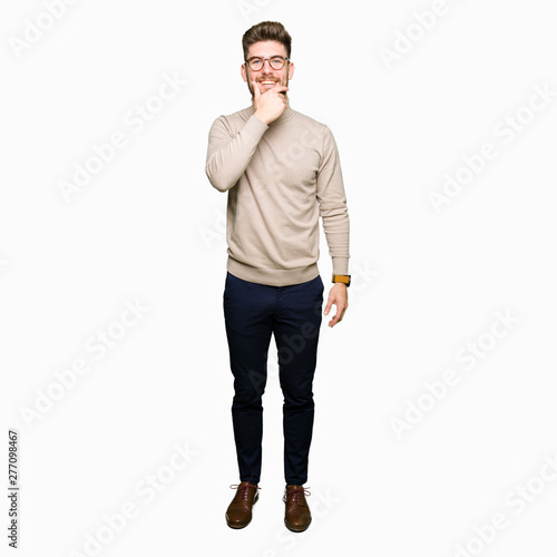 Young handsome business man wearing glasses looking confident at the camera with smile with crossed arms and hand raised on chin. Thinking positive.