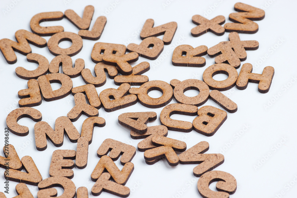 Many wooden letters on white background close up Many wooden letters on white background close up