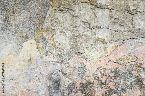 Textured grunge background. Old plastered wall with a multilayer cracked coating. Grunge texture with a deep pattern on the wall