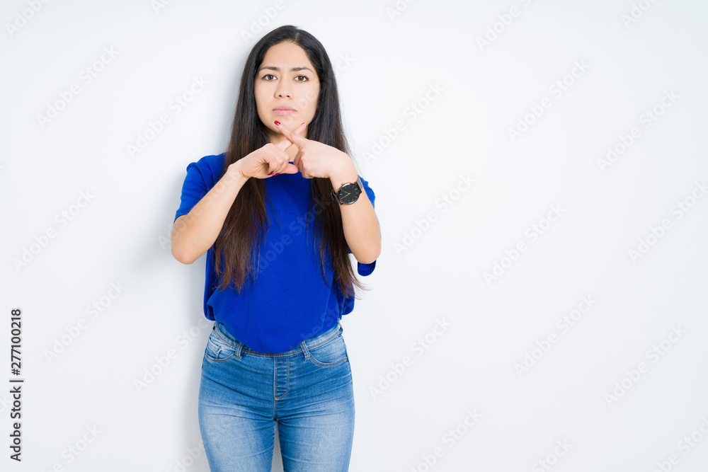 Beautiful brunette woman over isolated background Rejection expression crossing fingers doing negative sign Beautiful brunette woman over isolated background Rejection expression crossing fingers doing negative sign