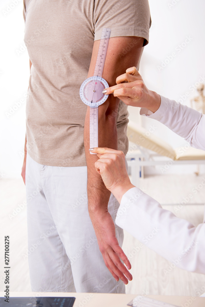 Obraz premium Female doctor checking patient's joint flexibility with goniometer