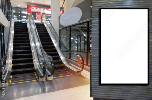 blank showcase billboard or advertising light box for your text message or media content in front of escalator in modern department store shopping mall, commercial and marketing concept