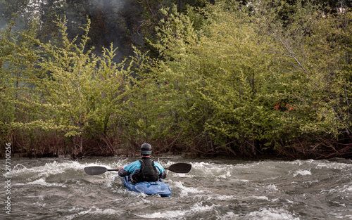 A Man on a Kayak Cautiously Navigating Past Smoke and Fire on the Kern River