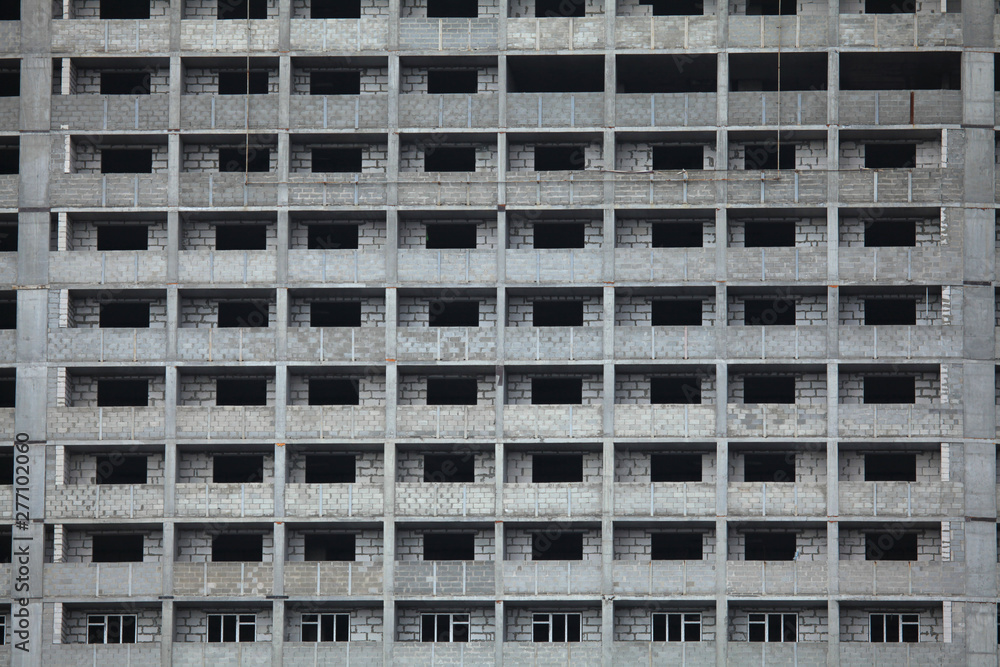 The fragment of the facade of unfinished and abandoned monolithic residential building. Windows of the multi-storey building The fragment of the facade of unfinished and abandoned monolithic residential building. Windows of the multi-storey building