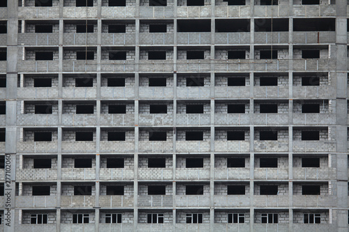 The fragment of the facade of unfinished and abandoned monolithic residential building. Windows of the multi-storey building