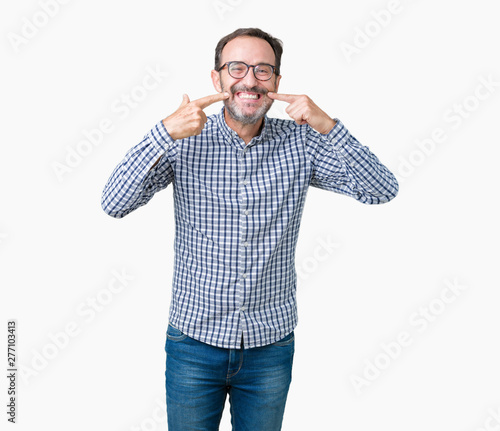 Handsome middle age elegant senior business man wearing glasses over isolated background smiling confident showing and pointing with fingers teeth and mouth. Health concept.