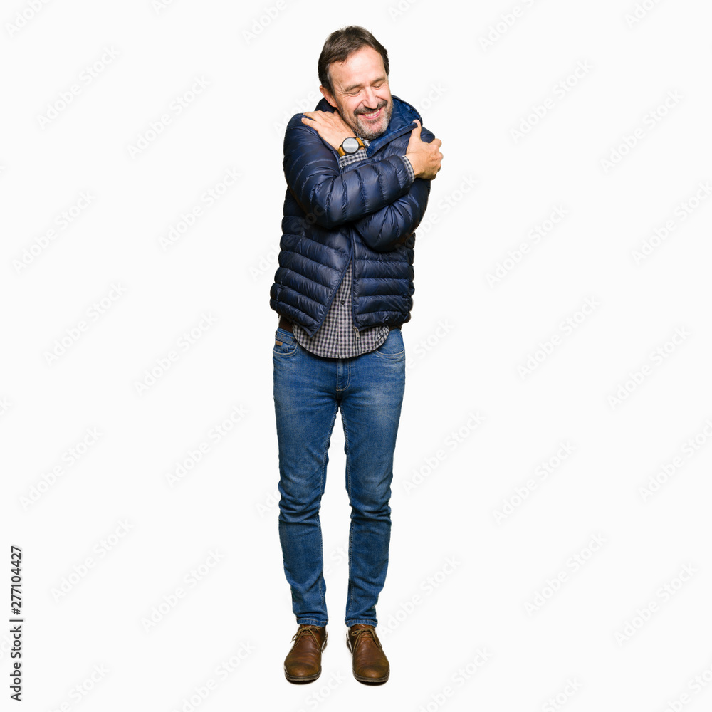 Middle age handsome man wearing winter coat Hugging oneself happy and positive, smiling confident. Self love and self care Middle age handsome man wearing winter coat Hugging oneself happy and positive, smiling confident. Self love and self care