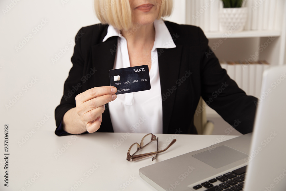 Woman using credit card online in office Woman using credit card online in office