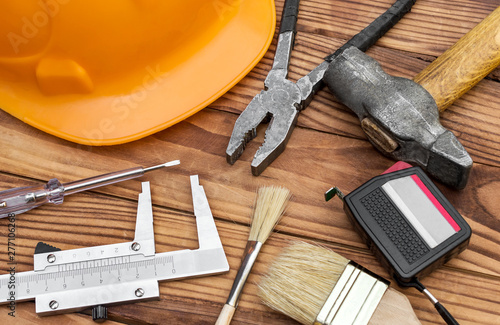 Worker's hard hat and construction toolls on the table. photo