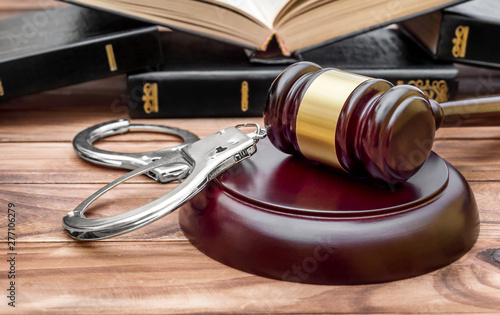 Konstfotografi Gavel, handcuffs and books on the table. Law and justice concept.