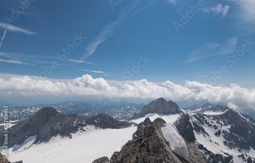 Gletscher auf dem Hintergrund der Berggipfel und blauer Himmel mit mehreren Wolken