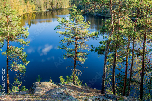 Beautiful forest pond view through trees and rock in Nuuksio National Park, Finland