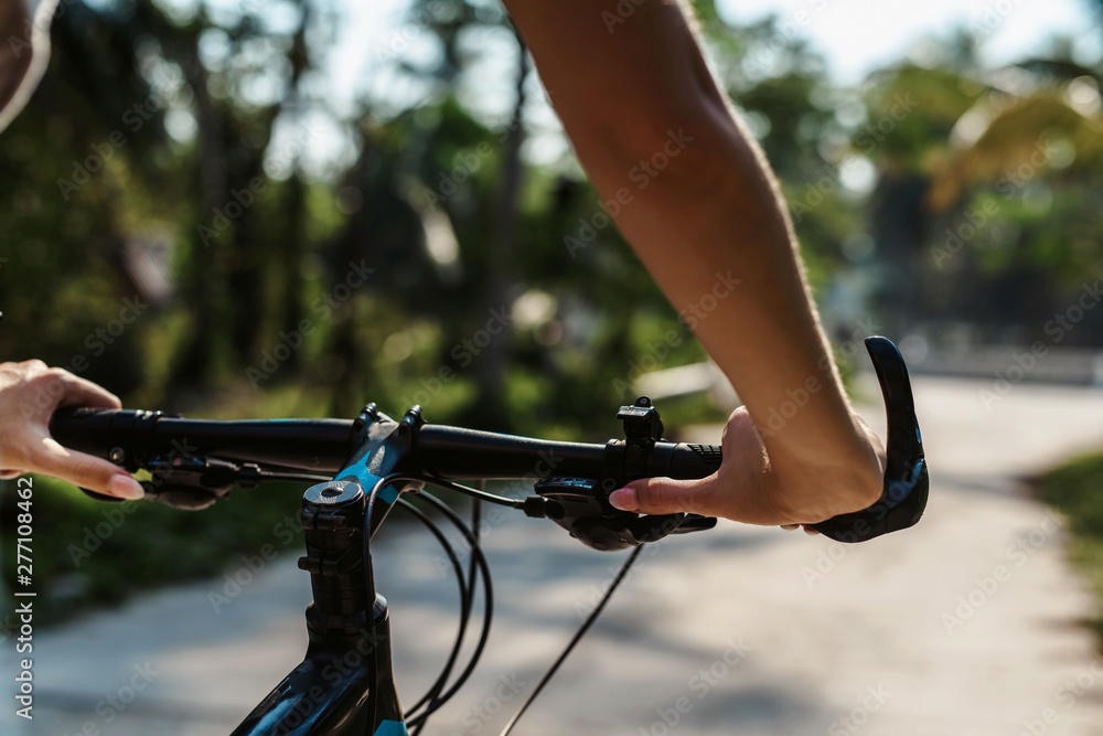 Pretty woman with Bicycle on a background of palm trees forest. Young girl riding bike in Vietnam or Thailand tropical jungle with coconut palms. Summer holiday tourist activity. Active sports tourism