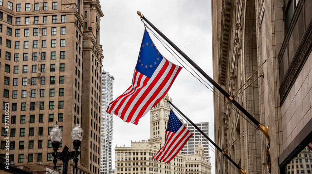 American flag in Chicago, Illinois downtown. Highrise buildings and cloudy sky background.