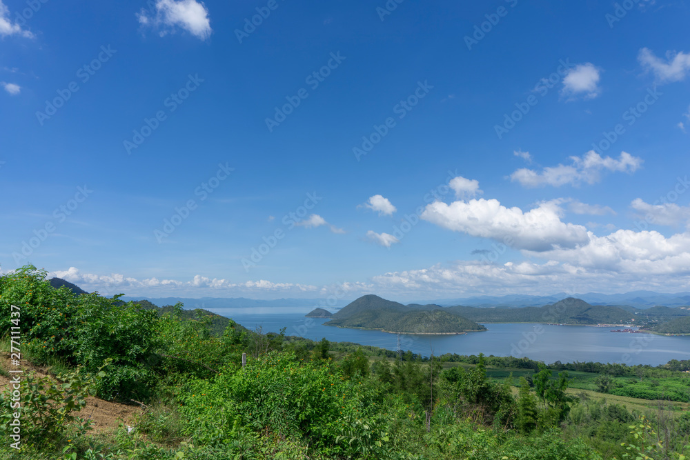 Clear blue sky white clouds, trees, natural grass trees around the Srinakarin Reservoir, Kanchanaburi, Thailand