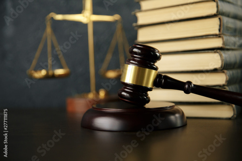 Judge gavel, scales of justice and law books in court