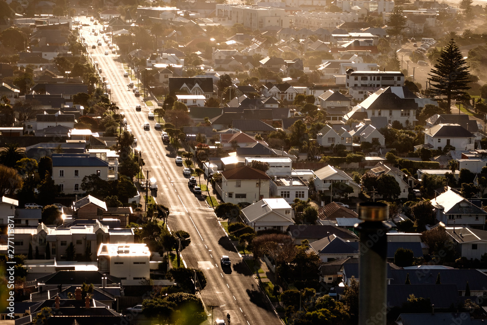 Aerial view of road, traffic, housing and buildings. Local suburb neighborhood image.