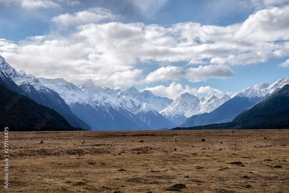 Nature landscape image of snow mountain and green grass field at Eglinton Valley, Te Anau, New Zealand. Beautiful scenery of south island, New Zealand.