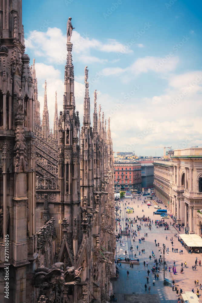 Fototapeta premium Widok osób korzystających z Piazza del Duomo z ozdobną architekturą katedry w Mediolanie, Lombardia, Włochy