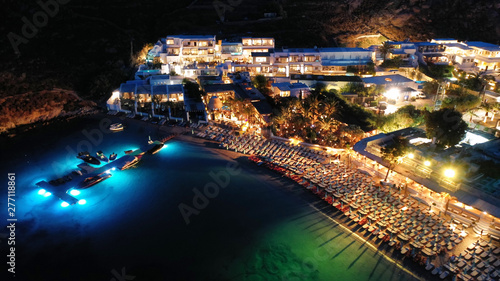Aerial drone night shot of famous Psarou beach with luxury resorts and yachts docked, Mykonos island, Cyclades, Greece