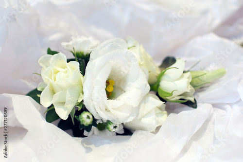 white wedding flowers against a white silk background