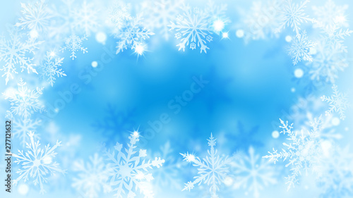 Christmas blurred background with frame of complex defocused big and small snowflakes in light blue colors with bokeh effect © Olga Moonlight