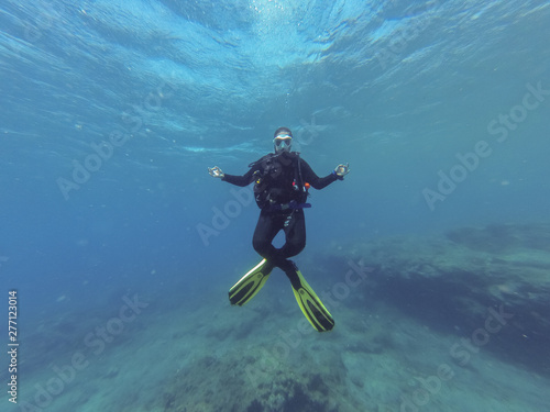 Young female scuba diver in the lotus yoga position during a dive in Atlantic ocean
