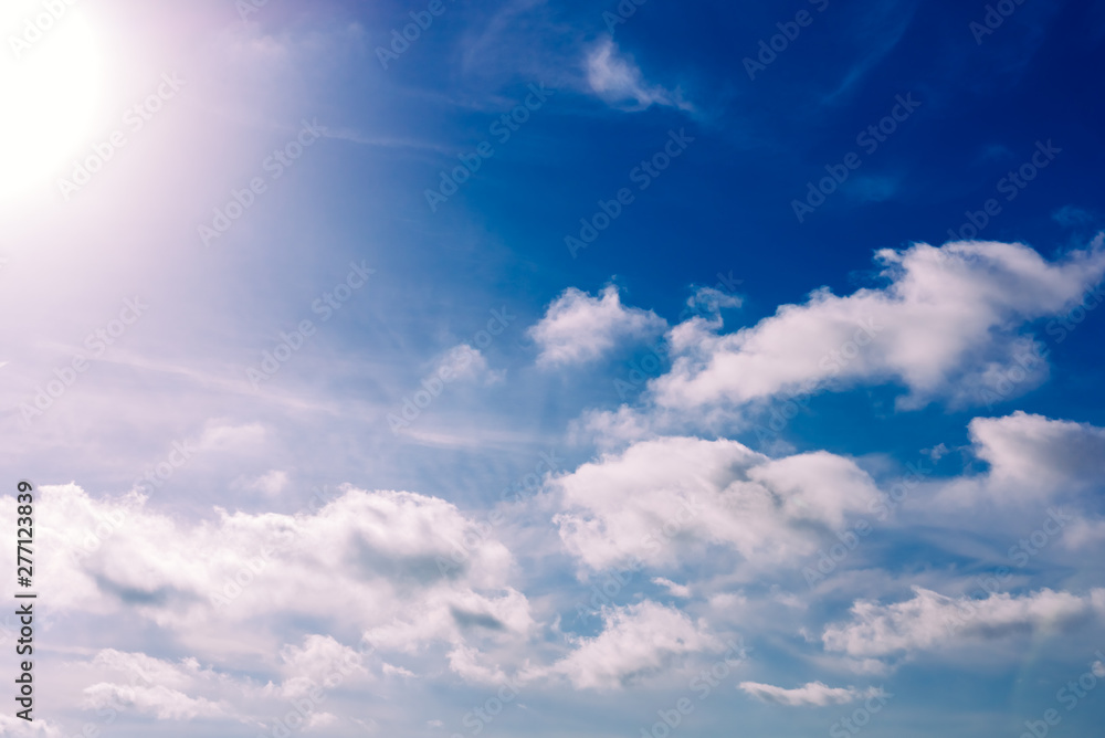 Glowing sun in a blue summer sky with nice white clouds. Glowing sun in a blue summer sky with nice white clouds.