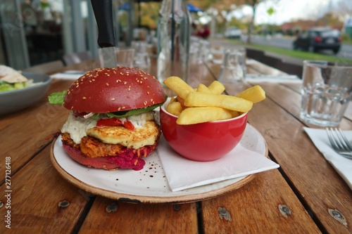 Sweet potato burger with haloumi in a beet bun with a side of fries