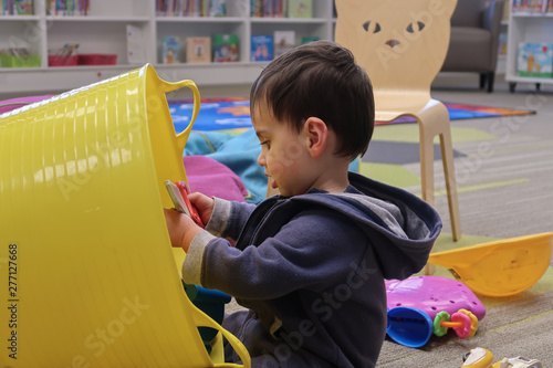 Young child playing in children's area of library