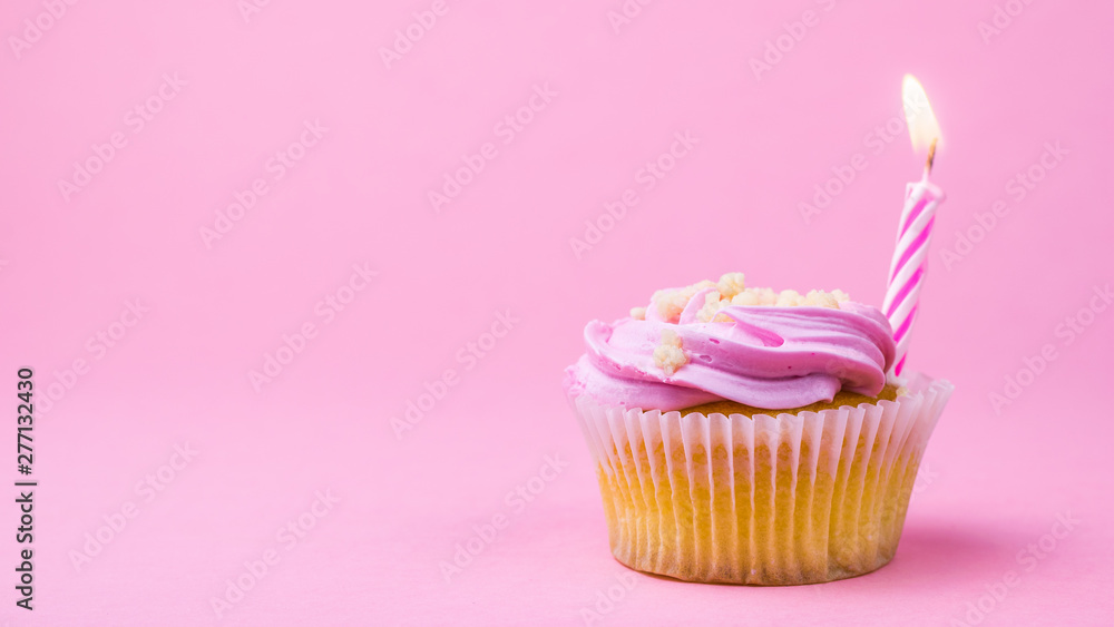 Cupcakes with berry cream and a candle on a pink background. Cupcakes with berry cream and a candle on a pink background.
