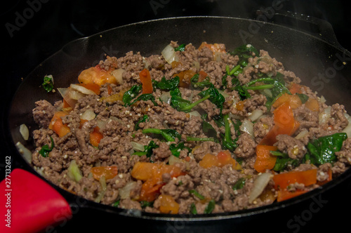 Cast iron skillet cooking ground beef pasta sauce mixture
