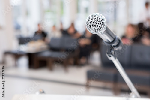 Microphone on the funeral podium and people wearing black in the church