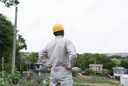 Photography 新興住宅街に立つヘルメットの男性　宅地開発　現地調査　用地買収