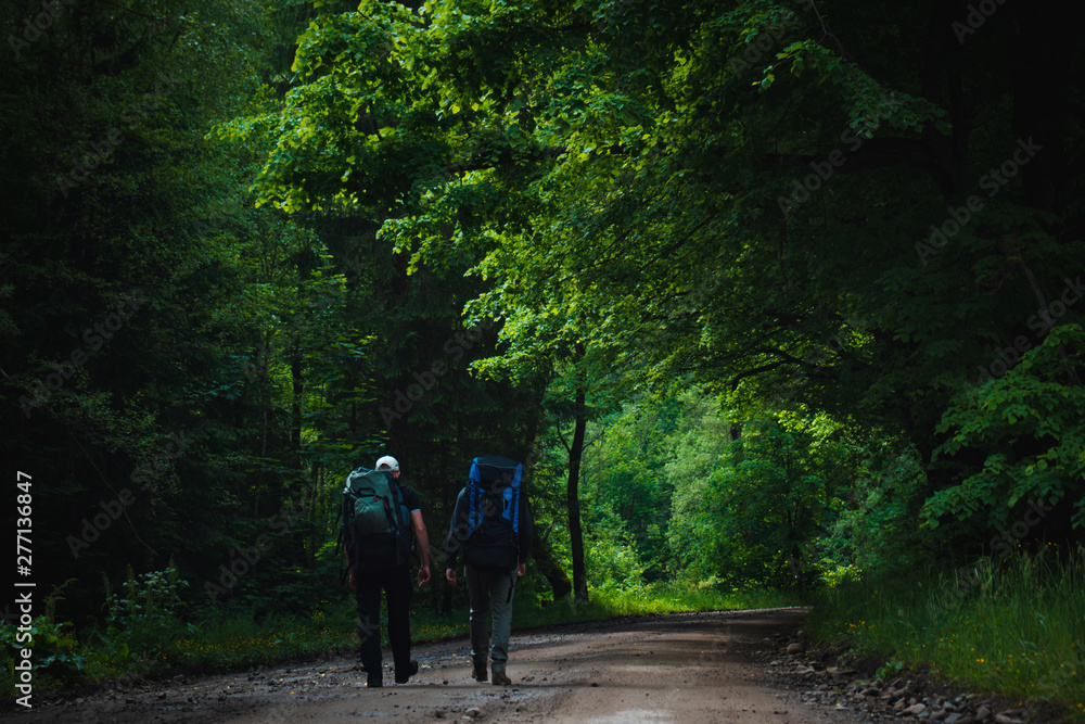 Two friends travel in the mountains with backpacks Two friends travel in the mountains with backpacks