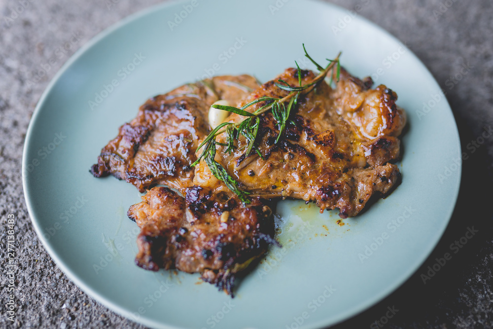 Round plate with grilled beef steak and rosemary