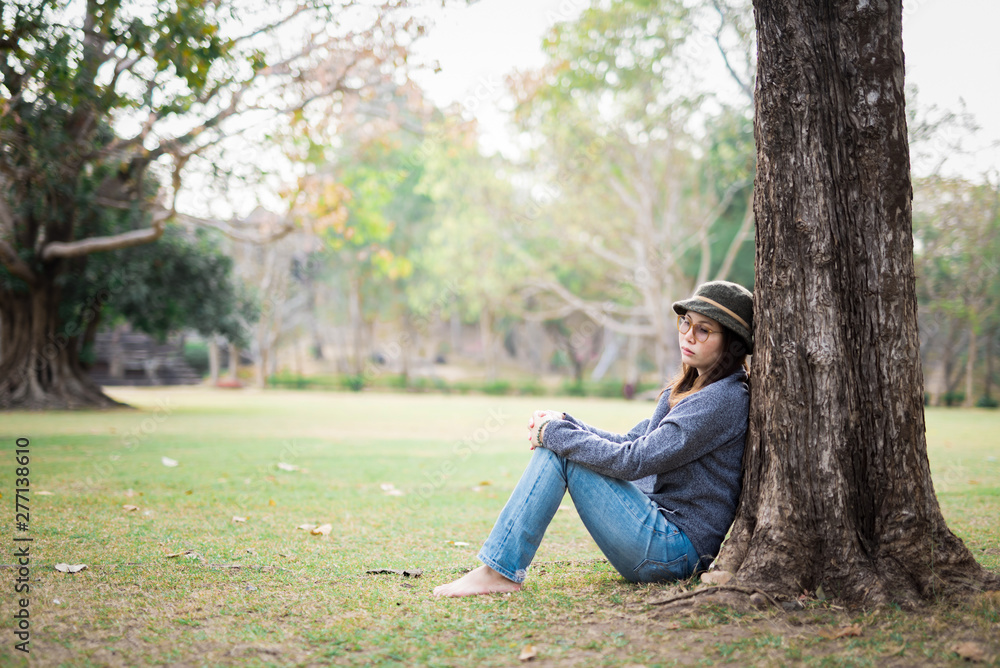 Sad woman sit down in field with sunlight background. Sad woman sit down in field with sunlight background.