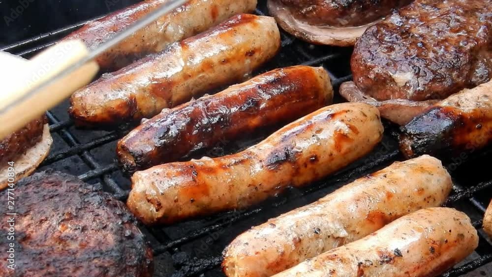 BBQ sausages cooking on outdoor grille, smoke & flames grilling food. BBQ sausages cooking on outdoor grille, smoke & flames grilling food.