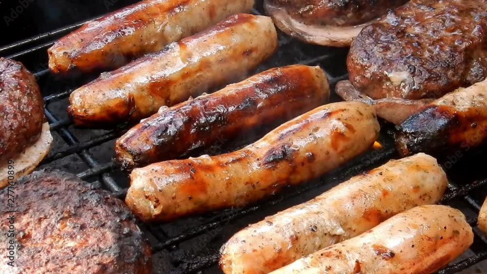 BBQ sausages cooking on outdoor grille, smoke & flames grilling food. BBQ sausages cooking on outdoor grille, smoke & flames grilling food.